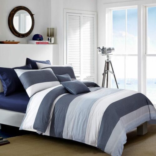 A bed with blue and white striped sheets.