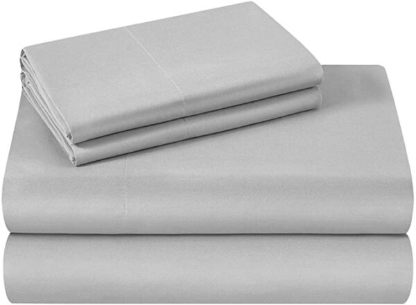 A bed with two folded sheets and one is folded in half.