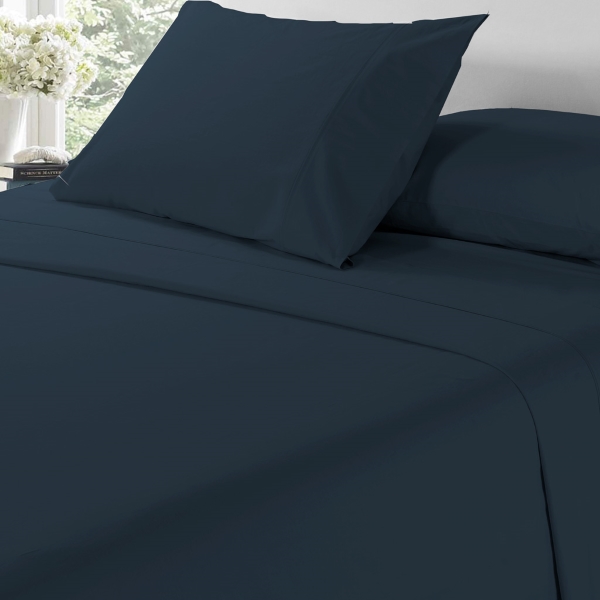 A bed with dark blue sheets and pillows