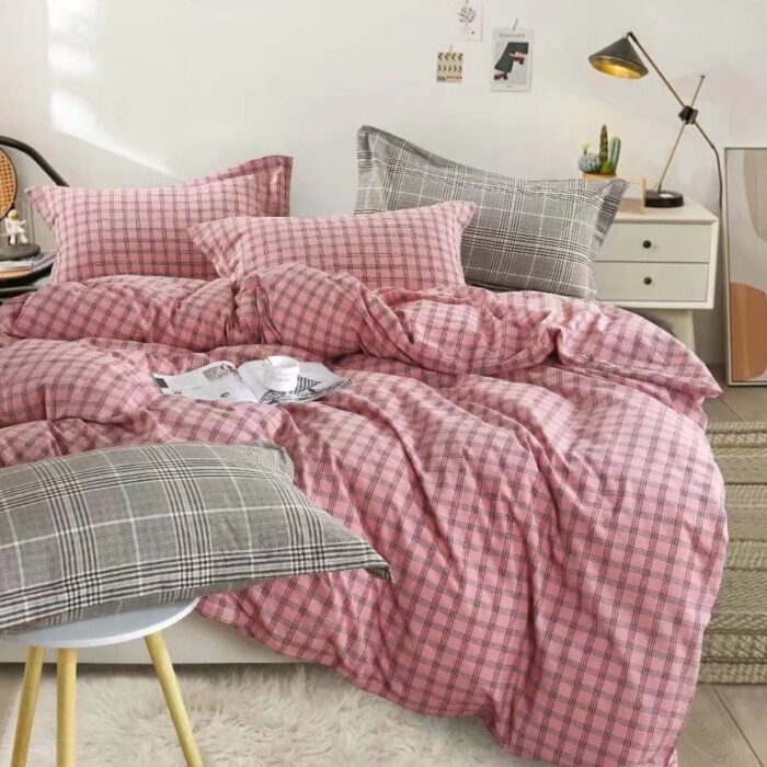 A bed with pink and grey sheets on it