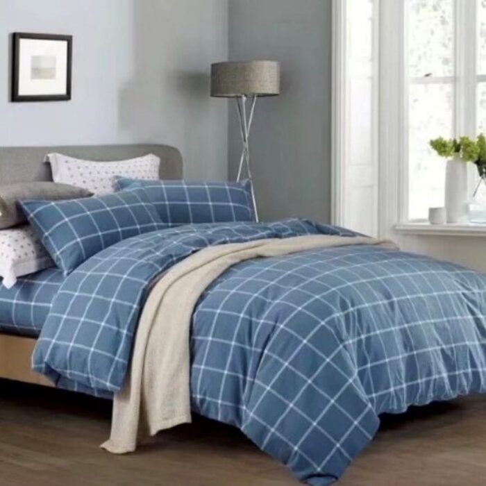 A bed with blue and white plaid sheets on it