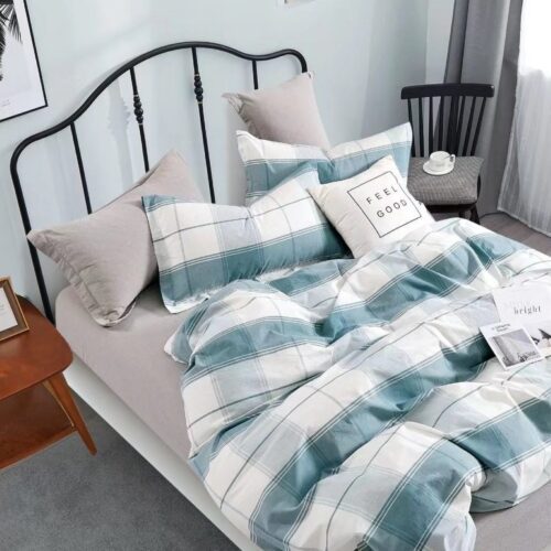 A bed with blue and white plaid sheets on it.