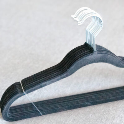 A black wooden hanger with metal wire on top.